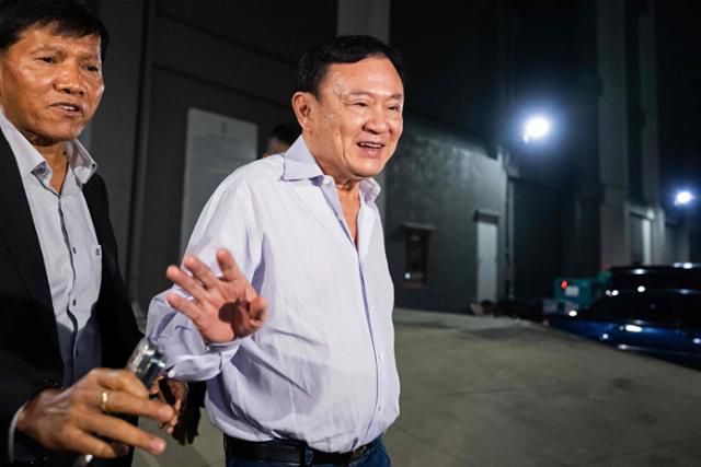 탁신 친나왓 전 태국 총리가 지난달 29일 방콕 푸어타이당 당사를 나서며 지지자들에게 인사하고 있다. 방콕=AFP 연합뉴스