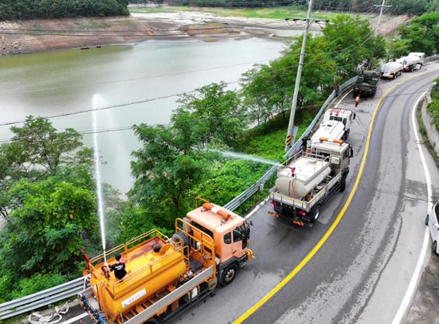 최악의 가뭄 사태가 이어지는 강원 강릉시의 주요 상수원인 오봉저수지 옆 도로에서 5일 살수차들이 저수율을 높이기 위해 물을 뿌리고 있다. 강릉=연합뉴스