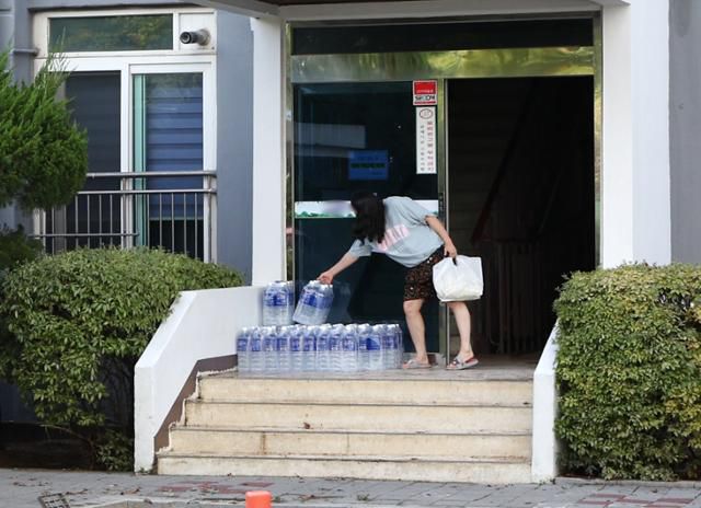 전북 군산시 문화동 한 아파트에서 7일 밤사이 내린 집중호우로 수돗물 공급이 끊기자 시에서 제공한 생수를 한 주민이 가져가고 있다. 뉴스1
