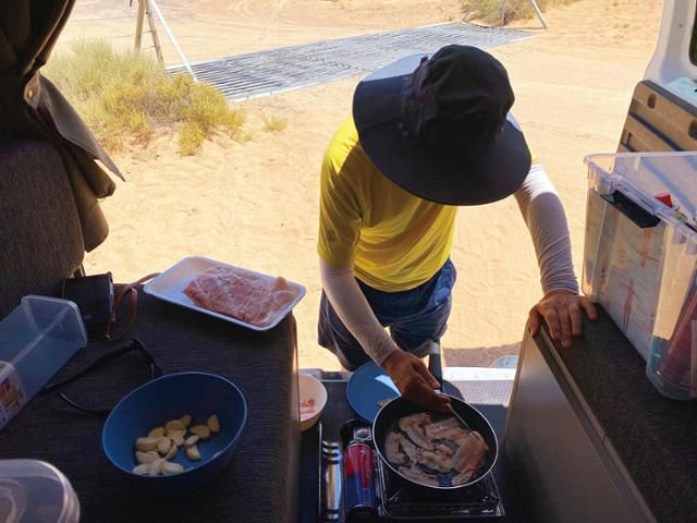 안정훈씨가 로드 트립 중 차 안에서 삼겹살을 굽고 있다. 그는 화려한 여행 보다는 가성비 좋은 여행을 선호한다. 이번 여행에서도 100달러 미만의 자동차 모텔에서 숙박하는 등 최대한 경비를 아꼈다. 에이블북 제공