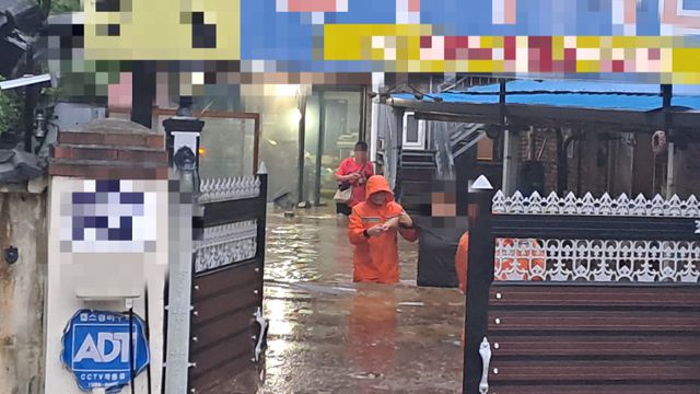 7일 전북 전주시 색장동 일대에 도로와 주택 등이 잠기자 주민이 소방대원의 도움을 받아 대피하고 있다. 전북소방본부 제공