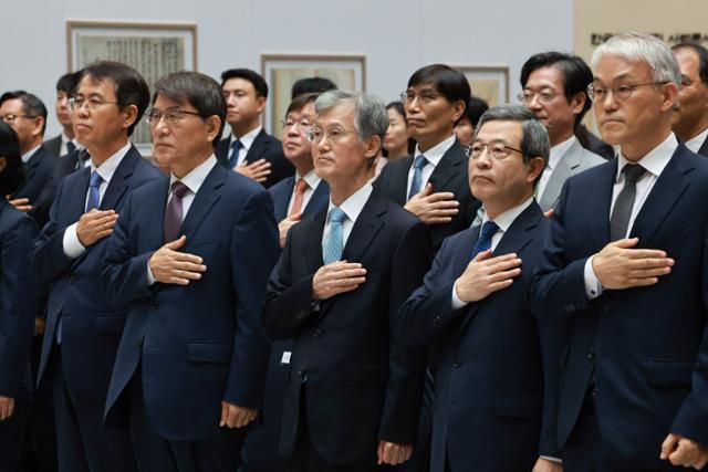 조희대 대법원장(가운데)이 12일 서울 서초구 대법원에서 열린 '2025 대한민국 법원의 날 기념식'에서 국기에 경례하고 있다. 연합뉴스