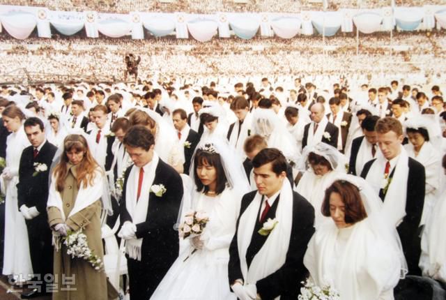 1999년 2월 7일 서울 잠실 올림픽주경기장에서 통일교 신자 대규모 합동 결혼 행사가 열리고 있다. 신혼 부부 1만2,000쌍과 기혼 부부 3만 쌍이 참여했다. 한국일보 자료사진