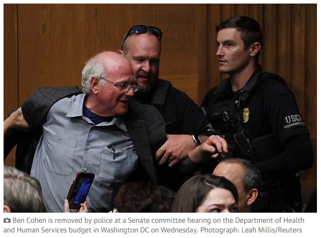 벤 코헨 벤앤제리스 창립자가 올해 5월 14일 워싱턴 미 상원에서 진행된 로버트 F. 케네디 주니어 장관 후보의 청문회에서 갑자기 일어나 가자지구 어린이들의 기아 문제를 지적하며 소리 지르자 현장 경비들이 그를 제지하고 있다. 가디언 홈페이지 캡처