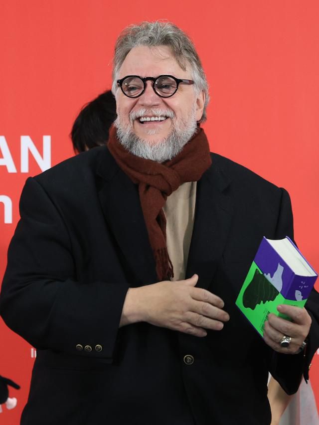 기예르모 델 토로 감독이 19일 부산 해운대구 영화의전당에서 열린 제30회 부산국제영화제 갈라 프레젠테이션 초청작 '프랑켄슈타인' 기자회견에서 영화제 측으로부터 선물 받은 책인 '한국 괴물 백과'를 들고 미소짓고 있다. 뉴스1