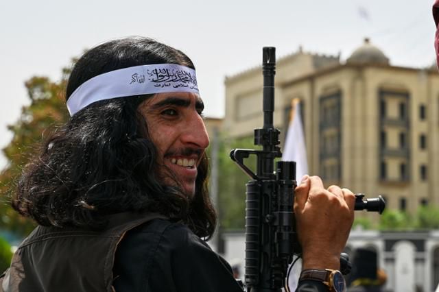 한 이슬람 무장단체 탈레반 조직원이 8월 15일 아프가니스탄 카불에서 미국 철수 4주년을 기념하는 행사에 참석해 미소 짓고 있다. 카불=AP 연합뉴스