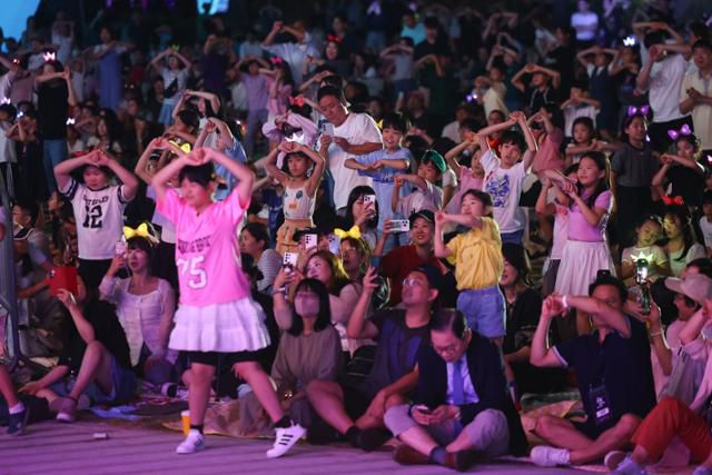 서울 시민과 관광객들이 지난 14일 서울광장에서 열린 2025 서울헌터스 페스티벌에서 넷플릭스 애니메이션 '케이팝데몬헌터스' 수록곡 '소다팝' 포인트 안무를 따라 추고 있다. 연합뉴스