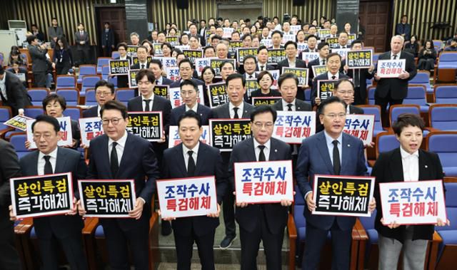 장동혁 국민의힘 대표와 송언석 원내대표를 비롯한 의원들이 13일 서울 여의도 국회에서 열린 긴급 의원총회에서 특검을 규탄하는 피켓을 들고 구호를 외치고 있다. 뉴시스