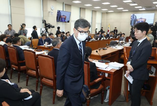 황인수 진실화해를위한과거사정리위원회 조사1국장이 14일 서울 여의도 국회에서 열린 행정안전위원회 행안부 등 국정감사에서 마스크 벗으라는 요구를 거부한 뒤 퇴장 당하고 있다. 뉴시스