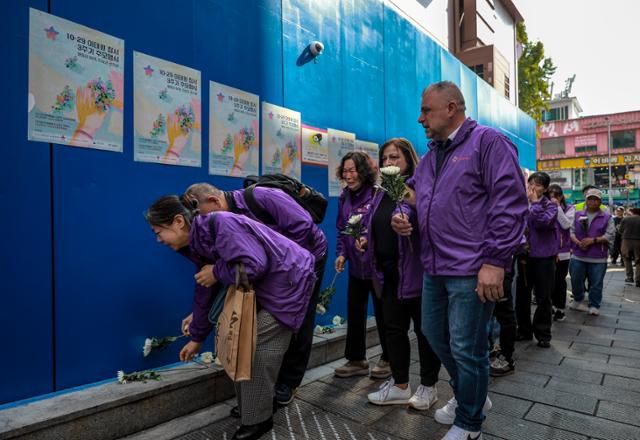 10.29이태원참사 외국인 희생자 유가족들이 25일 서울 용산구 이태원역 1번 출구 앞 10·29 기억과 안전의 길을 찾아 참사 현장을 살펴보며 헌화를 하고 있다. 뉴시스