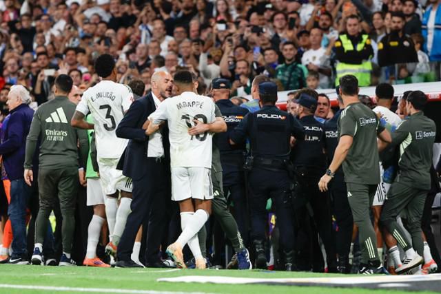 27일(한국시간) 스페인 마드리드의 산티아고 베르나베우에서 열린 2025~26시즌 스페인 라리가 레알 마드리드와 FC바르셀로나의 10라운드가 종료된 뒤 '벤치클리어링'이 벌어지자 경찰 인력이 투입돼 저지하고 있다. 마드리드=EPA 연합뉴스