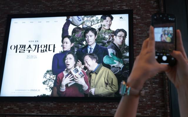 9월 25일 서울도심의 한 영화관에서 관객들이 박찬욱 감독의 영화 어쩔수가없다 포스터 앞에서 기념촬영을 하고 있다. 뉴스1