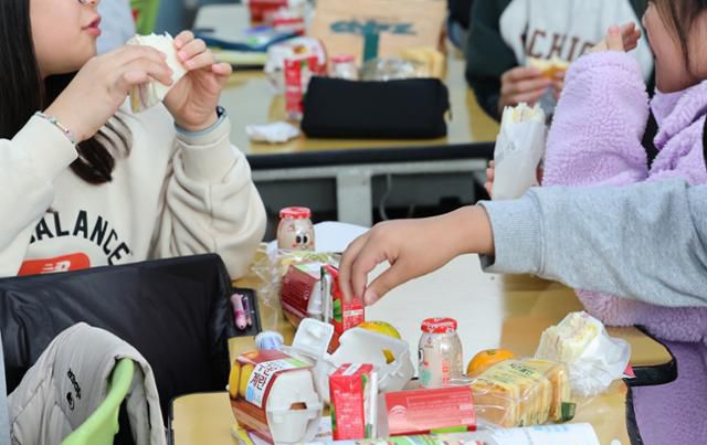 학교 비정규직 노동자들이 파업에 돌입한 20일 인천 한 초등학교 교실에서 학생들이 구운 달걀, 주스, 햄치즈샌드위치 등 대체 급식으로 점심을 먹고 있다. 연합뉴스