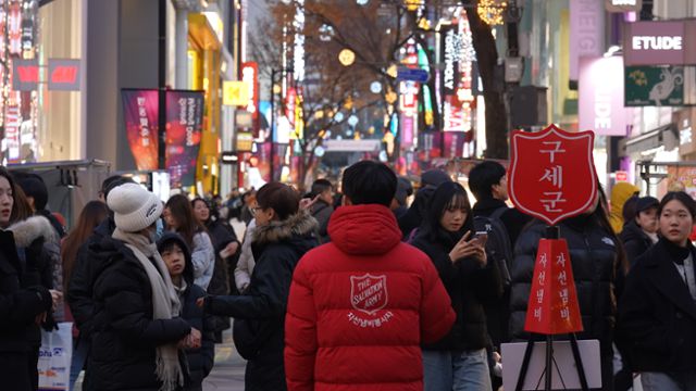 구세군 자선냄비 봉사자가 서울 명동 거리에서 자선냄비를 지키고 있다. 구세군한국군국 제공