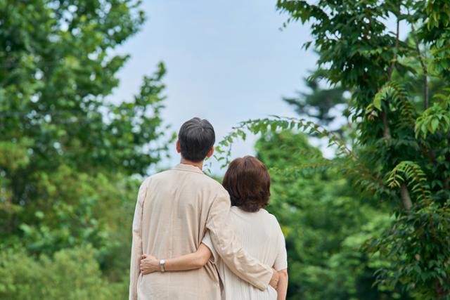 부부 한 쌍이 서로의 허리를 감은 채 하늘을 바라보고 있다. 게티이미지뱅크