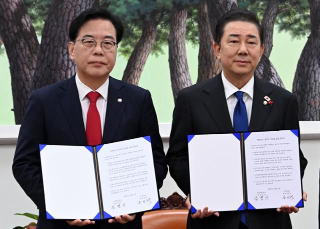 송언석(왼쪽) 국민의힘 원내대표, 김병기 더불어민주당 원내대표가 2일 서울 여의도 국회에서 2026년도 예산안 처리를 위한 합의문에 서명을 마치고 기념촬영을 하고 있다. 뉴스1
