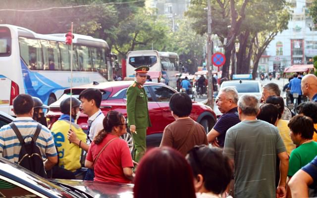 지난 1일 베트남 하노이 관광지인 호안끼엠 호수 인근에서 도로 정리에 나선 교통 공안 앞으로 관광객들이 지나고 있다. 하노이=허경주 특파원