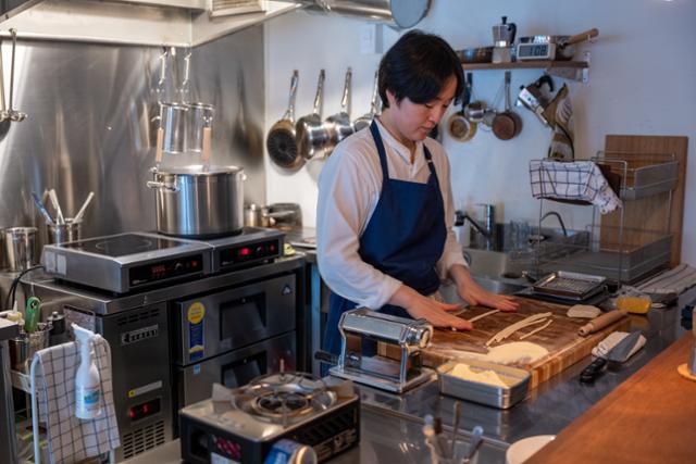 신정원 셰프가 주방에서 우동 면처럼 굵은 피치 파스타를 만들고 있다.