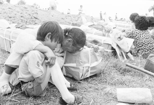 1980년 5월 29일 광주 시민들의 장례식에서 유족이 관에 얼굴을 묻고 오열하는 모습. 이하 사진들은 모두 광주 임시취재반에 파견된 사진부 기자들이 촬영한 것으로, 당시 신군부의 검열에 막혀 전부 보도되지 못하다가 약 40년이 지나서야 뒤늦게 공개됐다. 한국일보 임시취재반