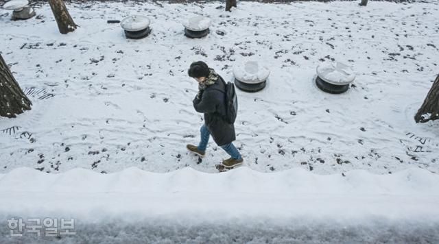 폭설 후 한파로 내린 눈이 얼어붙은 5일 오전 서울 중구 덕수궁 옆으로 한 시민이 출근길 발걸음을 옮기고 있다. 류효진 선임기자