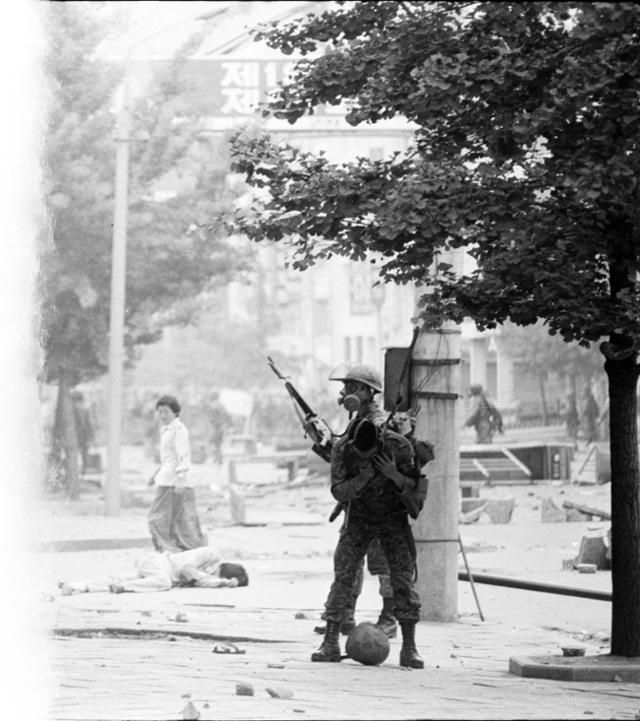 1980년 5월 20일 광주 금남로에서 투석전이 벌어진 직후 한 청년이 나뒹굴고 있다. 주변 계엄군의 서슬에 겁을 먹은 여성은 그를 도울 수도, 지나칠 수도 없다. 무자비한 진압은 그 후로도 계속됐다. 임시취재반