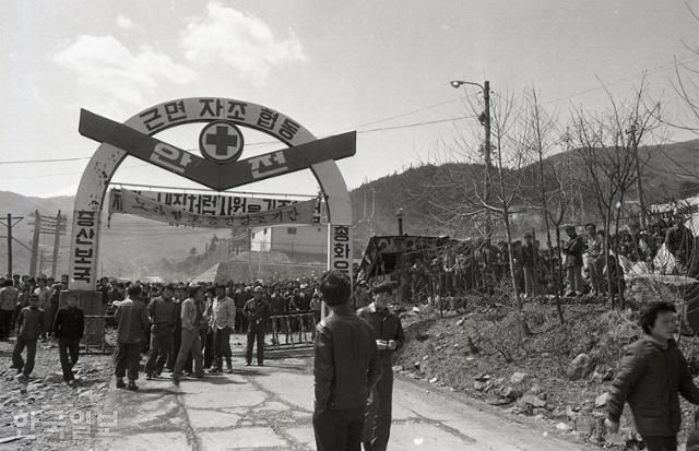 1980년 4월 23일 강원 정선군 사북읍의 광업소 정문을 광부들이 지키고 있다. '증산보국', '노사협조증진강조기간' 등의 글씨가 정문에 적혀있다. 한국일보 자료사진