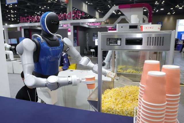 5일 경기도 고양시 킨텍스에서 열린 2025 로보월드에서 휴머노이드 로봇이 관람객의 주문에 팝콘을 담고 있다. 고양=연합뉴스