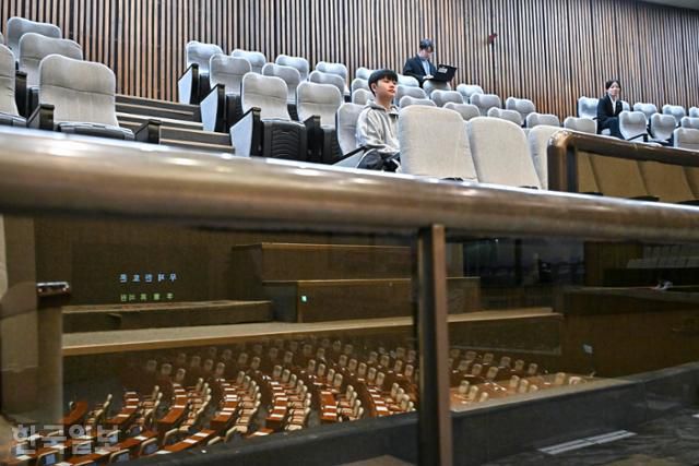 천곡중 신민재 학생(위)이 12일 국회에서 열린 본회의에서 무제한 토론(필리버스터)을 방청하고 있다. 유리에 필리버스터가 진행 중인 국회 본회의장이 비쳐 보이고 있다. 정다빈 기자