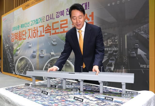 오세훈 서울시장이 18일 시청에서 강북횡단 지하고속도로 건설 계획에 대해 설명하며 모형 고가를 들어보이고 있다. 뉴스1