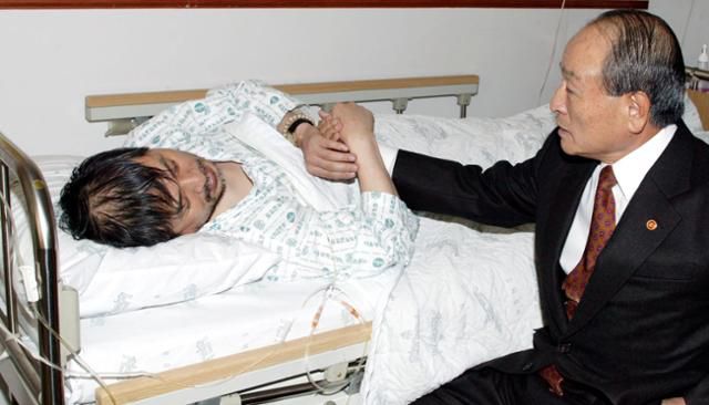 2005년 12월 8일 오명 부총리 겸 과학기술부 장관이 서울대병원에 입원한 황우석 교수를 찾아 위로하고 있다. 그는 서울대의 논문 검증에 반대하고 발표를 늦추라고 압박했다. 연합뉴스