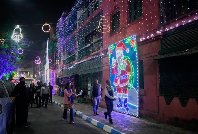 23일 인도 콜카타의 보우 배럭 주택가에서 시민과 관광객들이 크리스마스 장식이 된 거리를 거닐고 있다. 콜카타=AP/뉴시스