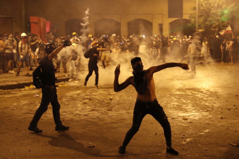 9일(현지시간) 레바논 수도 베이루트에서 정권 퇴진을 요구하는 시위대들이 전경을 향해 돌을 던지는 모습. 전날 베이루트 시내에는 5000명의 시민들이 국회의사당을 향해 돌을 던지고, 외교부를 비롯한 일부 정부 부처 건물을 점거하는 등 거친 시위를 벌였다. [AP]