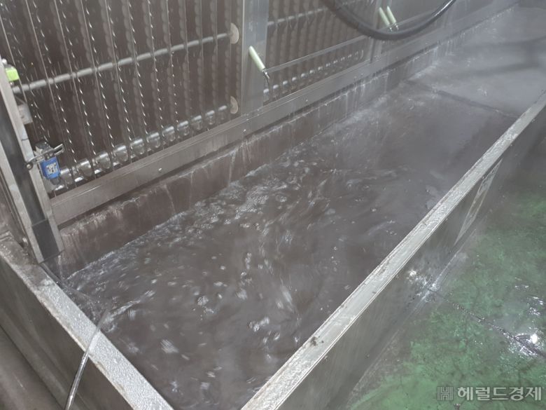 미세먼지 집진기를 물 청소하자 새카만 물들이 모이고 있다. [이진용 기자/jycafe@heraldcorp.com]