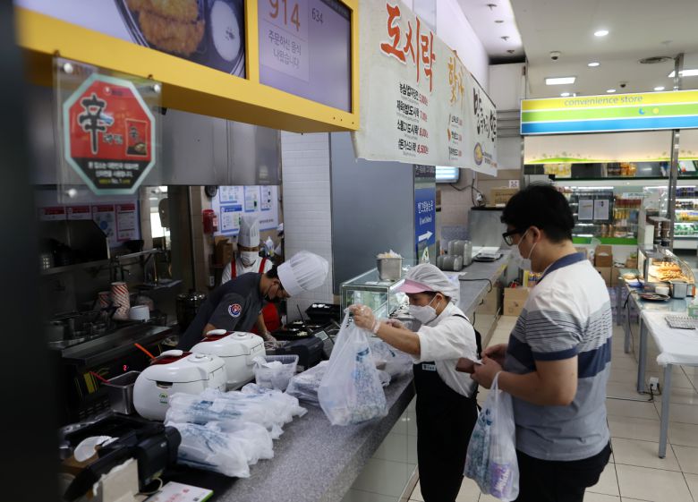 코로나19 확산방지를 위해 29부터 다음 달 4일까지 총 6일간 고속도로 휴게소 실내매장에서는 좌석 운영이 금지된다. 대신 음식물을 포장해 갖고 가는 테이크아웃은 가능하다. 29일 오후 서초구 서울만남의광장(부산방향) 식당에서 한 시민이 주문한 도시락을 받고 있다. [연합]