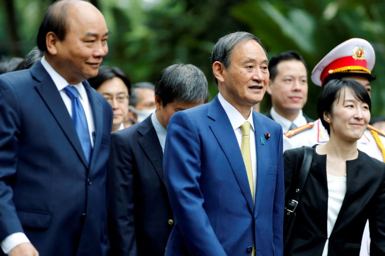 베트남을 방문 중인 스가 요시히데(菅義偉·오른쪽 두 번째) 일본 총리가 19일(현지시간) 베트남 하노이 소재 베트남 총리 관저에서 응우옌 쑤언 푹(왼쪽 첫 번째) 베트남 총리와 만나 함께 걸어가고 있다. [로이터]