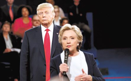 2016년 10월 대선 후보 타운홀 토론에서 도널드 트럼프 대통령이 당시 민주당 후보인 힐러리 클린턴의 발언을 듣고 있다. 클린턴은 대선 레이스 내내 우세를 점했지만 선거를 앞두고 이른바 ‘이메일 스캔들’에 휘말리면서 결국 대권 도전에 실패했다. [로이터]
