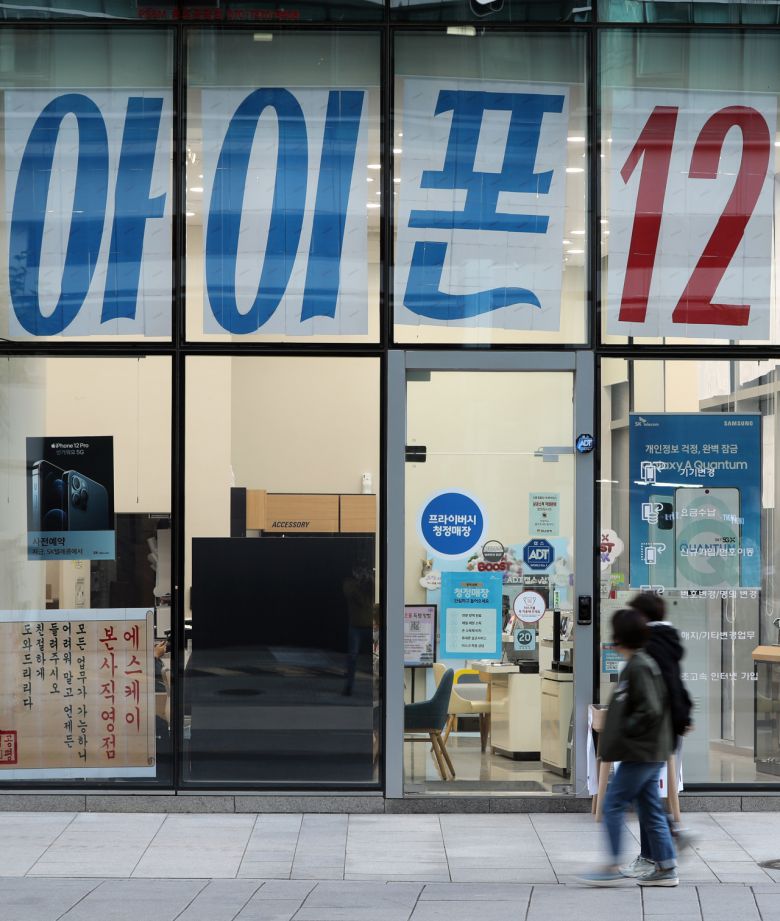 아이폰12 예약이 시작된 23일 서울 종로구 휴대전화 판매점 앞을 시민들이 지나고 있다. [연합뉴스]