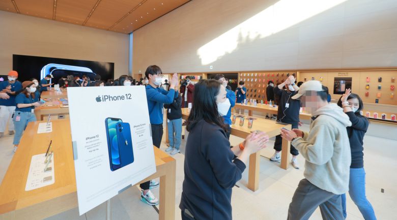 애플 신제품 아이폰12가 정식 출시된 30일 오전 서울 강남구 신사동 애플 가로수길 매장을 찾은 시민들이 직원들의 환호를 받으며 입장하고 있다. 연합뉴스