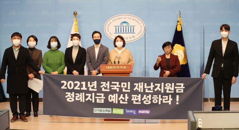 용혜인 기본소득당 의원, 녹색당, 미래당, 여성의당 당원들이 4일 국회 소통관에서 2021년 전국민 재난지원금 정례지급 예산 편성을 촉구하고 있다. [연합]