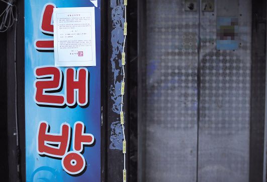 6일 오전 서울의 한 노래방 앞에 집합 금지 명령 안내문이 붙어 있다. 신종 코로나바이러스 감염증 장기화로 사회적 거리두기 강화 조치가 연장되자 이에 반발하는 자영업자들의 움직임이 심상치 않은 가운데 노래방·호프집·PC방 등으로도 반발이 확산하는 모양새를 보이고 있다. [연합]