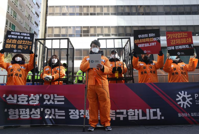 필라테스 피트니스 사업자 연맹 관계자들이 지난 5일 오전 서울 영등포구 더불어민주당 당사 앞에서 열린 기자회견에서 실내체육시설의 '사회적 거리두기' 방역지침에 따라 운영에 차질을 빚고 있는 것과 관련해 정부에게 실효성과 형평성 있는 정책을 촉구하고 있다. [연합]