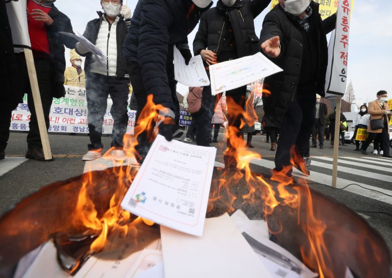 한국유흥음식업중앙회 경남도지회원이 지난 21일 오후 경남 창원시 의창구 경남도청 입구에서 영업 허가증을 불에 태우고 있다. [연합]