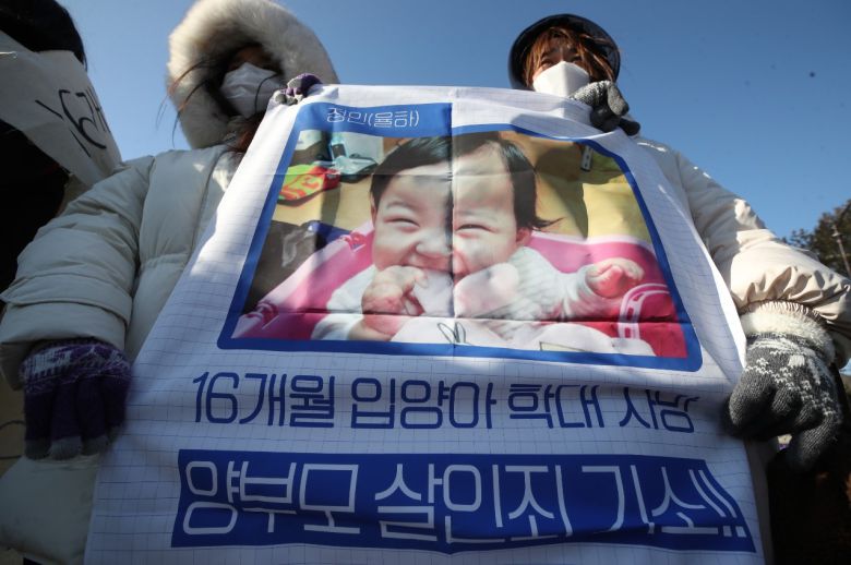 지난 7일 서울 청와대 분수대 앞에서 열린 '보건복지부는 직무유기한 홀트아동복지회 특별감사 실시'를 촉구하는 기자회견에서 참석자들이 '양부모 살인죄 기소'라는 손팻말을 들고 있다. [연합]