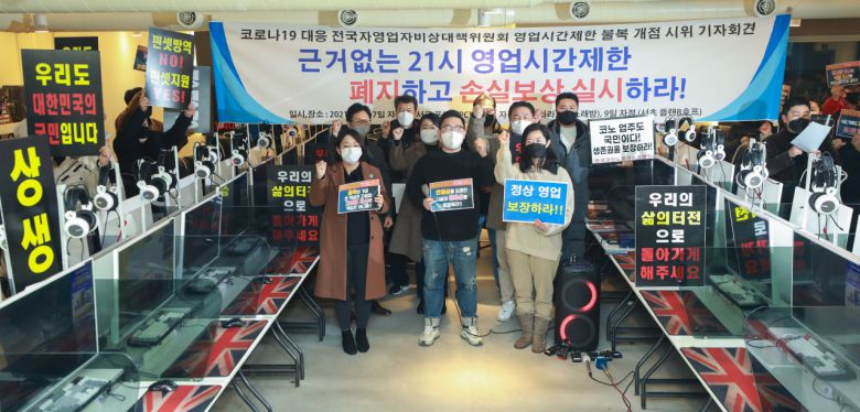 8일 자정 서울 강서구의 한 PC방에서 코로나19 대응 전국자영업자 비상대책위 주최로 열린 방역 기준 불복 개점 시위에서 참석자들이 정상 영업을 촉구하며 구호를 외치고 있다. [연합]