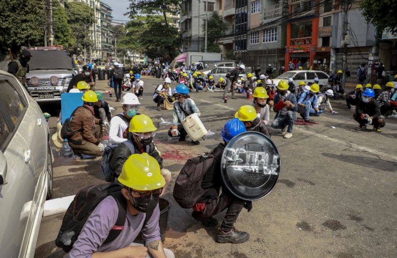 3일(현지시간) 미얀마 최대 도시 양곤에서 반(反) 쿠데타 시위대가 진압에 나선 군경의 실탄·고무탄 공격을 피하기 위해 안전모를 착용한 채 낮은 자세로 앉아있는 모습. [AP]