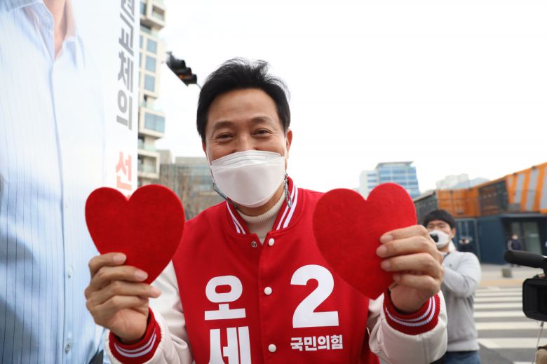 오세훈 국민의힘 서울시장 후보가 주말인 지난 27일 서울 성동구 서울숲에서 양손에 하트를 들고 지지를 호소하고 있다. 국회사진기자단