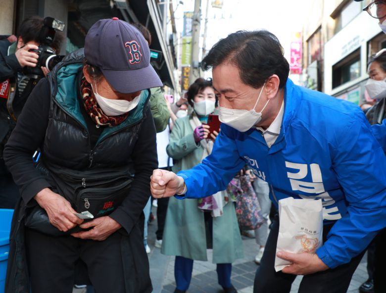 4·7 부산시장 보궐선거에 도전하는 김영춘 더불어민주당 후보가 30일 오후 부산 수영 팔도시장에서 상인들과 인사를 나누고 있다. [연합]
