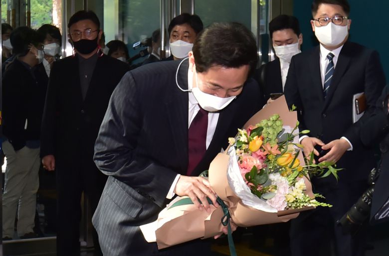 제38대 서울시장에 당선된 오세훈 신임 시장이 8일 서울 종로구 서울시청 본관에 출근, 직원들로부터 축하 꽃다발을 받은 후 고개 숙여 인사하고 있다. 연합뉴스