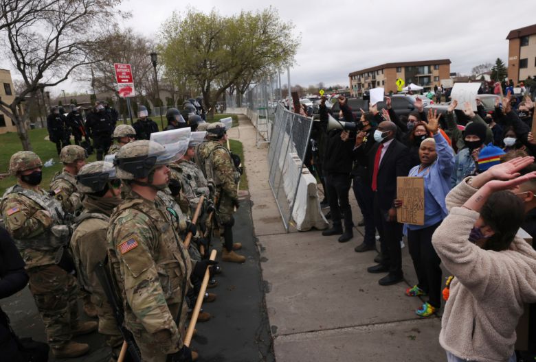 12일(현지시간) 비무장 흑인 단테 라이트(20)가 경찰이 쏜 총에 맞아 사망한 사건이 벌어진 미국 미네소타주 브루클린센터에서 시위에 나선 시민들을 경찰과 주 방위군이 막아서고 있다. [로이터]