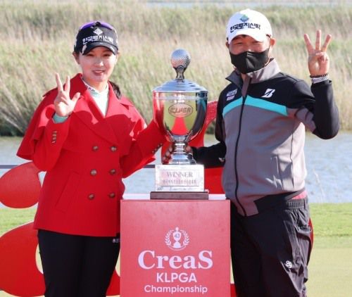 박현경이 크리스F&C KLPGA 챔피언십 우승 후 캐디를 한 부친과 트로피 옆에서 포즈를취했다. [사진=KLPGA]